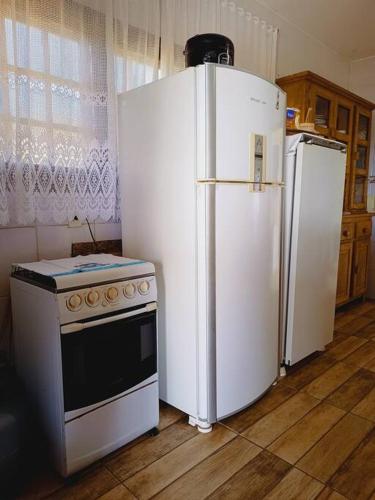 a kitchen with two refrigerators and a stove at Sítio São Sebastião em Monte Sião-MG in Monte Sião