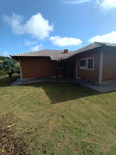 a house with a grass yard in front of it at Sítio São Sebastião em Monte Sião-MG in Monte Sião