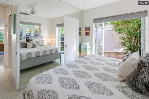 1 dormitorio con cama blanca y puerta de cristal en New Hidden Oasis by Brightwild- Waterfall Pool Close to Beach, en Key West