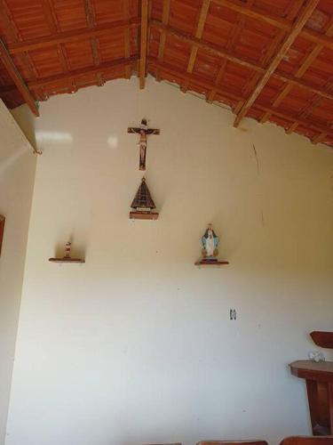 a room with a cross on the wall and a cross on a shelf at Sítio São Sebastião em Monte Sião-MG in Monte Sião