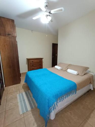 a bedroom with a large bed with a blue blanket at Sítio São Sebastião em Monte Sião-MG in Monte Sião