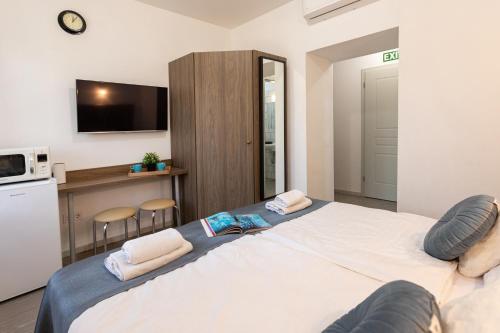 a bedroom with a large bed and a kitchen at Csillag Villa in Balatonalmádi