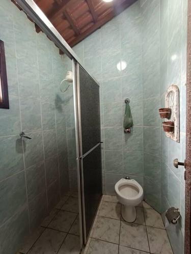 a bathroom with a toilet and a shower stall at Sítio São Sebastião em Monte Sião-MG in Monte Sião