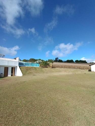a building in a field with a grassy field at Sítio São Sebastião em Monte Sião-MG in Monte Sião