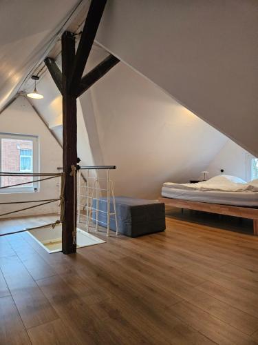 a loft bedroom with a bed and a wooden beam at 1897 Gästehaus der Villa Wilhelmshöhe in Münchberg