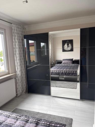 een slaapkamer met een bed en een grote spiegel bij Promienna Rezydencja - bright holiday home in Wolin