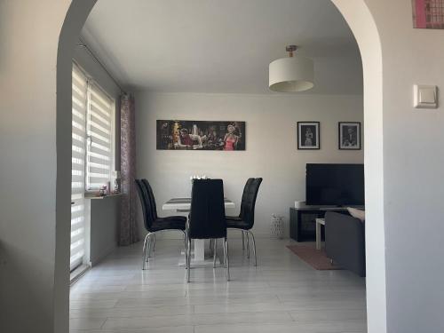 une salle à manger avec une table et des chaises noires dans l'établissement Promienna Rezydencja - bright holiday home, à Wolin