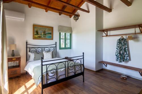 a bedroom with a black bed and a wooden floor at Traditional Farm House in Ermioni