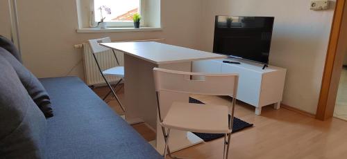 a room with a desk with a tv and a desk with a chair at Privatzimmer im Herzen von Iphofen in Iphofen