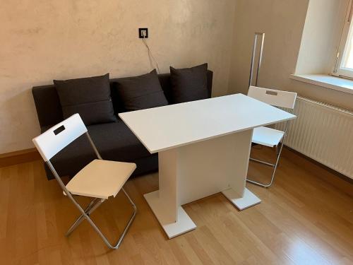 a white table and chairs in a living room with a couch at Privatzimmer im Herzen von Iphofen in Iphofen