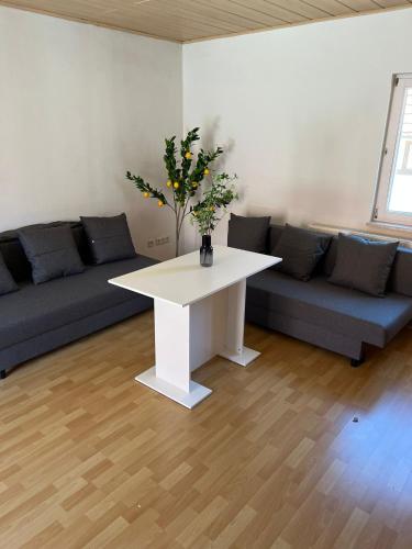 a living room with a white table and a couch at Privatzimmer im Herzen von Iphofen in Iphofen