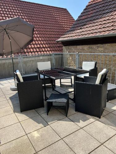 a patio with a table and chairs and an umbrella at Privatzimmer im Herzen von Iphofen in Iphofen