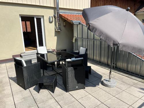 a patio with a table and chairs and an umbrella at Privatzimmer im Herzen von Iphofen in Iphofen