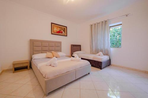 a bedroom with two beds and a window at Friends Villa in Sarandë