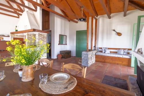 a dining room with a table and a couch at Green House on the hill in Ermioni