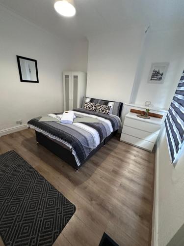 a bedroom with a large bed and a rug at 3 bed house in Leicester! in Leicester