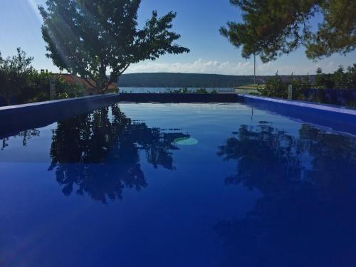 a swimming pool with a view of the water at Apartments Monika Bed & Breakfast in Punat