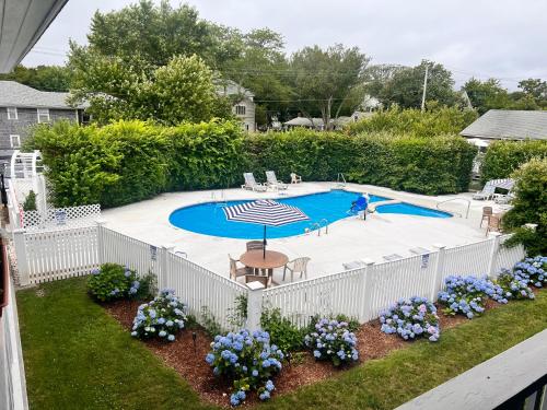 uma cerca branca à volta de uma piscina com flores em Edgartown Commons Vacation Apartments em Edgartown