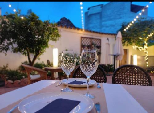 a table with two wine glasses on top of it at La Posada de Bayuela in Castillo de Bayuela