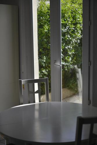 une table et deux chaises devant une fenêtre dans l'établissement Le Cottage de la Baie - vue mer en Baie de Somme, à Woignarue
