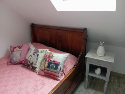 a bed with a wooden head board with a camera on it at La petite maison dans la prairie in Notre-Dame-du-Touchet