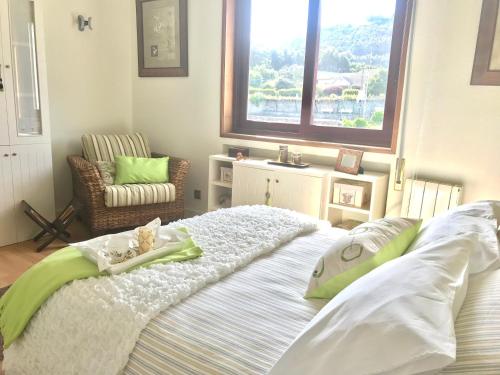 1 dormitorio con 1 cama grande y ventana en Apartamento en primera línea de playa, en A Guarda