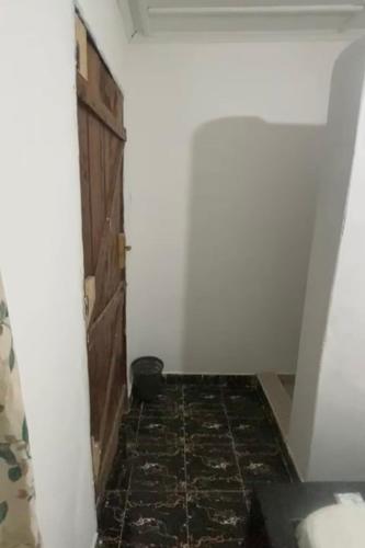 a room with a hallway with a door and a tile floor at Karemi’s Lounge Bar & Guesthouse. in Malindi