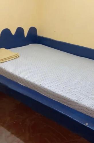 a blue bed with a white mattress on it at Karemi’s Lounge Bar & Guesthouse. in Malindi
