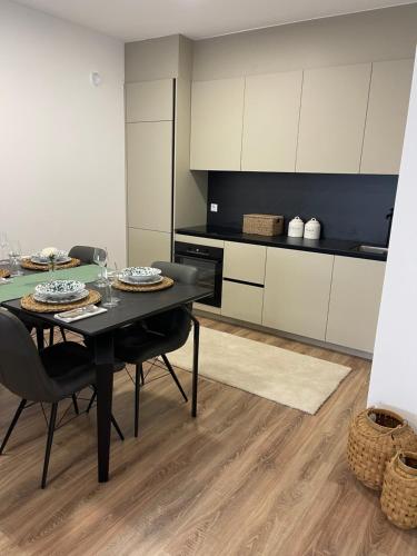 uma cozinha com mesa e cadeiras num quarto em Apartment Prishtina 038 em Pristina