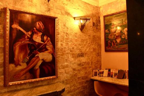 a bathroom with a painting of a man and a woman at Hotel DONIA in Hammam Chott