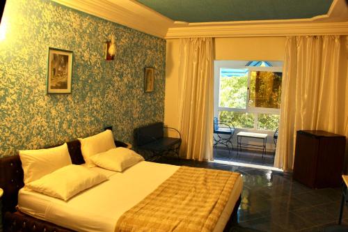 a bedroom with a large bed and a window at Hotel DONIA in Hammam-Plage