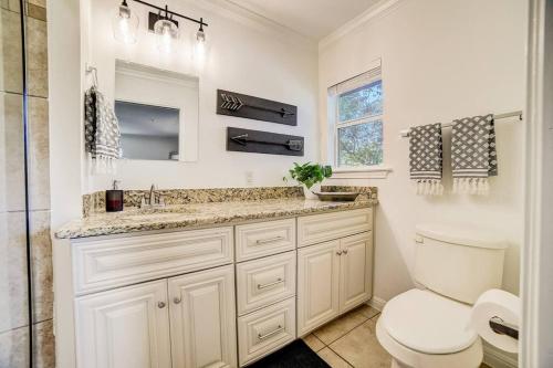 a white bathroom with a toilet and a sink at Walk to Schlitterbahn, River Access & Pets OK in New Braunfels