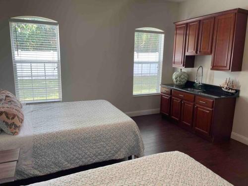 ein Schlafzimmer mit 2 Betten und eine Küche mit Fenstern in der Unterkunft Orlando 4 BR Home Centrally Located on Dead End St in Orlando