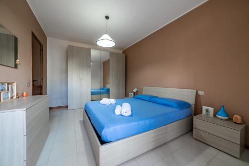 a bedroom with a blue bed with towels on it at Casa Acqua Marina vicino al mare con parcheggio privato in Quartu SantʼElena