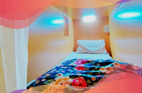 a bed with a colorful comforter in a room at Travelers Friend Capsule Near Sharaf DG metro station and rolla market in Dubai