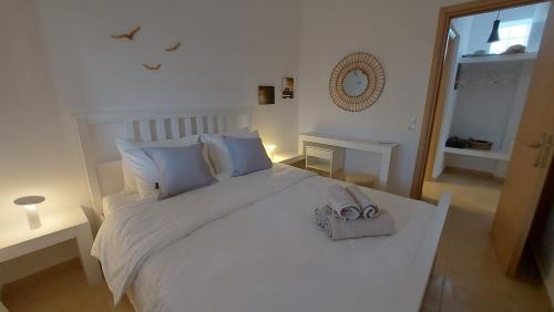 un dormitorio con una cama blanca con un bolso en Sea breeze houses en Monolithos