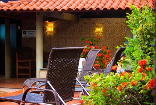 a group of chairs sitting on a patio with flowers at Pousada Encantos do Glória in São João Batista do Glória