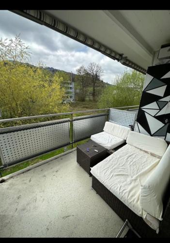 a balcony with a bed and a table on it at Yigits rom in Lucerne
