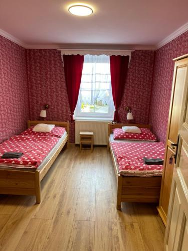 1 dormitorio con 2 camas y ventana en Restaurace a penzion u Kulíků, en Raspenava