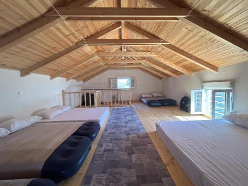 - 2 lits dans une chambre dotée de plafonds en bois dans l'établissement Natural Retreat Shelter #Unoblu®, 