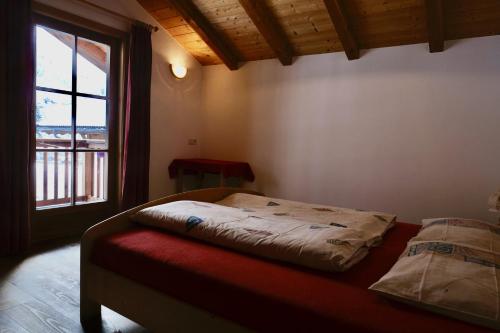 a bed in a room with a window at Ausser Brugghof in Senales