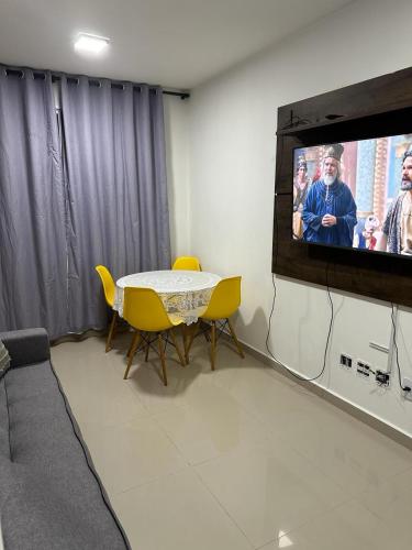 a living room with a tv and a table and chairs at APTO COMPLETO - MORADA DO OURO in Cuiabá
