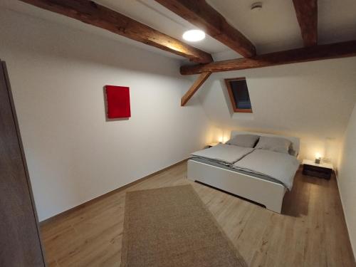 a bedroom with a bed in a room with wooden ceilings at Storchennest - Ferienwohnung am Storchenradweg in Ketzür
