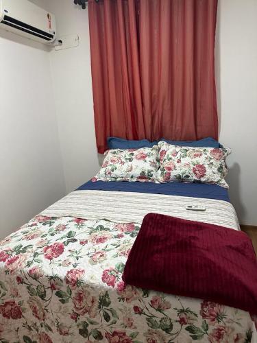 a bed in a room with a red curtain at APTO COMPLETO - MORADA DO OURO in Cuiabá