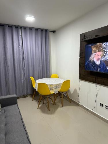 a room with a table and a flat screen tv at APTO COMPLETO - MORADA DO OURO in Cuiabá