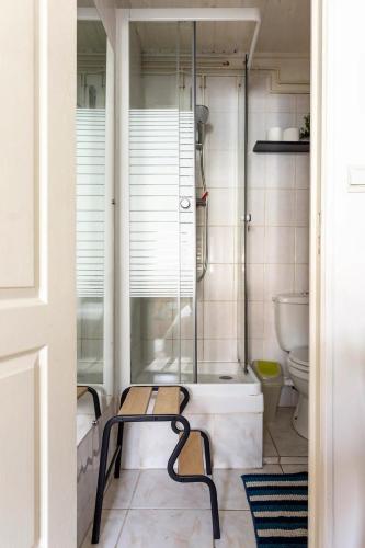 La salle de bains est pourvue d'une douche et d'un banc à côté des toilettes. dans l'établissement Chbre 2 pers, sdb privée, repas et Taxi CDG Extra, à Aulnay-sous-Bois