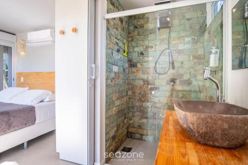 a bathroom with a stone tub in a bedroom at VGZ - Cabanas charmosas entre Barra de Ibiraquera e Rosa in Imbituba