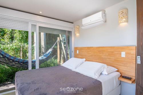 a bedroom with a bed and a hammock at VGZ - Cabanas charmosas entre Barra de Ibiraquera e Rosa in Imbituba