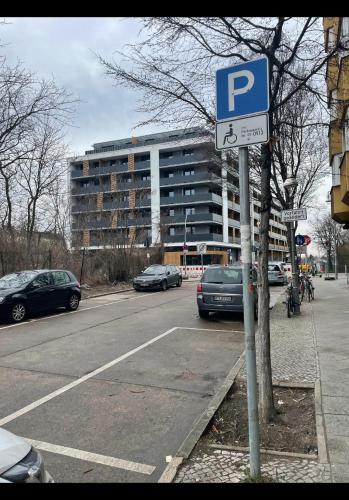 een parkeerplaats met een parkeerbord voor een gebouw bij Suite in Tempelhof in Berlijn