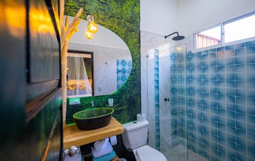 een badkamer met een wastafel, een toilet en een spiegel bij Ambos Mundos Hotel Boutique in Taganga
